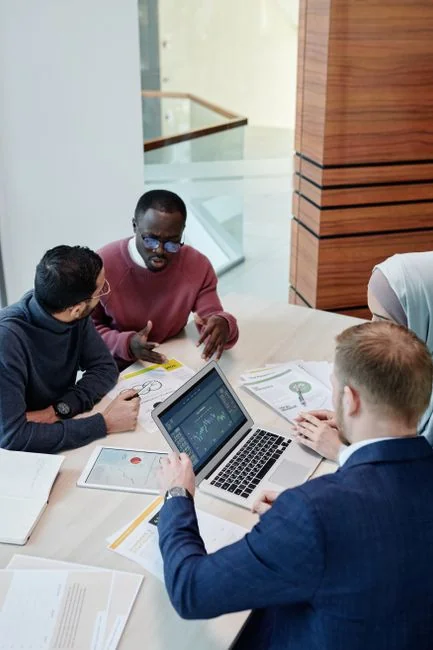 Suvremeno uređen uredski stol s računalom na kojem je prikazan poslovni graf.
